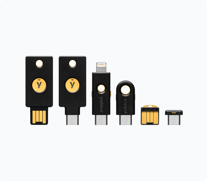 La imagen muestra seis llaves de seguridad de la marca Yubico, llamadas “YubiKeys”, estan alineadas en fila, tienen un diseño diferente cada una, con puertos usb-a, usb-c y algunas con combinaciones, todas en color negro y amarillo con el logo de la marca.